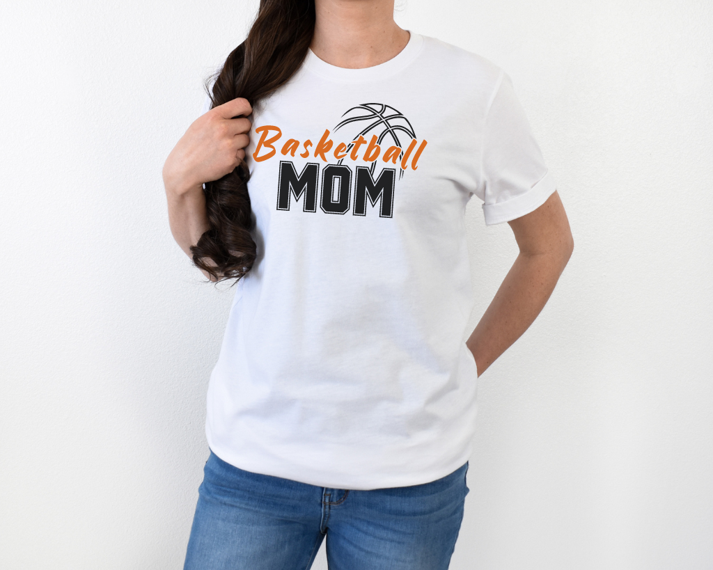 White basketball mom shirt with 'Basketball' in orange letters, 'Mom' in black letters, and a basketball outline above the word 'Basketball.