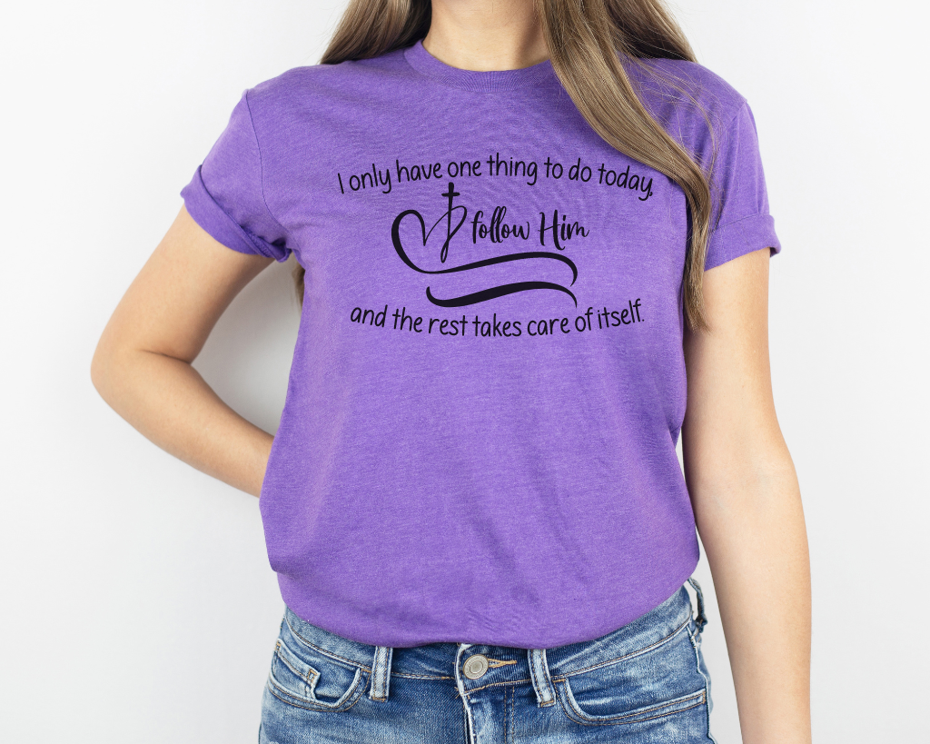 Christian purple shirt black lettering "I only have one thing to do today, follow him, and the rest takes care of itself" with black heart & cross